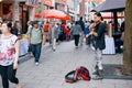 Young Asian female street musician playing violin and trying to collect money from people passing by in Chinatown, Montreal, Royalty Free Stock Photo