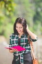 Young asian female student holding books while walking on the pa Royalty Free Stock Photo