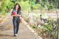 Young asian female student holding books while walking on the pa Royalty Free Stock Photo