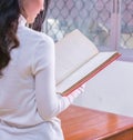 Young Asian female student portrait concentrate on studying and reading textbook in university library. Preparation for exams or