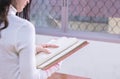 Young Asian female student portrait concentrate on studying and reading textbook in university library. Preparation for exams or