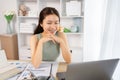 Young Asian female student watching teacher's live performance or video call on laptop in classroom at home Royalty Free Stock Photo