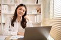 Young Asian female student watching teacher's live performance or video call on laptop in classroom at home Royalty Free Stock Photo