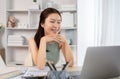 Young Asian female student watching teacher's live performance or video call on laptop in classroom at home Royalty Free Stock Photo