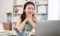 Young Asian female student watching teacher's live performance or video call on laptop in classroom at home Royalty Free Stock Photo