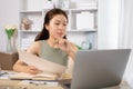 Young Asian female student watching teacher's live performance or video call on laptop in classroom at home Royalty Free Stock Photo