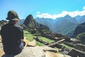 A young asian female traveler is admiring the Inca ruins of Machu Picchu, one of the New Seven Wonder of The World.