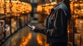 Young asian female warehouse worker using smartphone. This is a freight transportation and distribution warehouse. Industrial