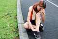 Young Asian fitness woman runner suffering from broken twisted ankle. Running injury accident concept.