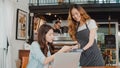 Young Asian freelance women pay contactless at coffee shop. Asian happy girl barista waiter wear gray apron holding credit card Royalty Free Stock Photo