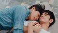 Young Asian gay couple sleep together at home. Teen korean LGBTQ+ men happy relax rest lying on bed in bedroom at house in the Royalty Free Stock Photo