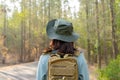 Young Asian girl with a backpack and hat hiking in the mountains during the summer season Royalty Free Stock Photo
