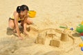 Young Asian Girl Building Sandcastle By The Beach Royalty Free Stock Photo