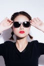 Young asian girl doing emotion. Dressed in a black shirt and yellow skirt, glasses and bright lips,trendy clothes. Royalty Free Stock Photo