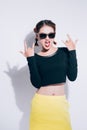 Young asian girl doing emotion. Dressed in a black shirt and yellow skirt, glasses and bright lips,trendy clothes. Royalty Free Stock Photo