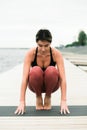 Young Pretty asian girl doing yoga outdoors on the pier by the lake Royalty Free Stock Photo