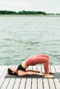 Young asian girl doing yoga outdoors on the pier by the lake Royalty Free Stock Photo