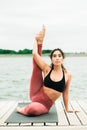 Young Pretty asian girl doing yoga outdoors on the pier by the lake Royalty Free Stock Photo