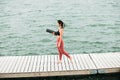 Young asian girl doing yoga outdoors on the pier by the lake Royalty Free Stock Photo