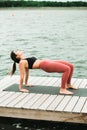 Young asian girl doing yoga outdoors on the pier by the lake Royalty Free Stock Photo