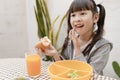 Young Asian girl eating breakfast and orange juice on the table at home still happy. Royalty Free Stock Photo