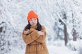Young asian girl freezes in the park waiting for a date, on a winter snowy day, a woman warmly dressed