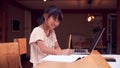 Young Asian Girl Home Schooling Working At Table Using Laptop