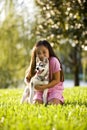 Young Asian girl hugging puppy sitting on grass Royalty Free Stock Photo