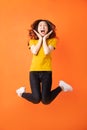 Young asian girl jumping up on orange background Royalty Free Stock Photo