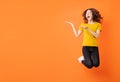 Young asian girl jumping up on orange background Royalty Free Stock Photo