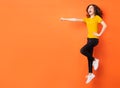 Young asian girl jumping up on orange background Royalty Free Stock Photo