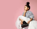 Young girl kid in long white skirt, grey fluffy sweater and black shoes sits and think something over Royalty Free Stock Photo