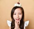 Young asian girl kid with sweet cherry dessert on head on a beige Royalty Free Stock Photo
