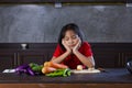 Young asian girl look at vegetable with bored face