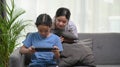 Young girl looking her sister playing games in living room. Royalty Free Stock Photo