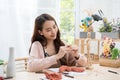 Young Asian girl making a sculpture with modeling clay at home .hobby clay sculpt concept.