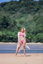 Young asian girl in pink bikini posing at tropical beach Royalty Free Stock Photo