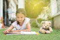 Young asian girl reading a book lying on her house lawn Royalty Free Stock Photo