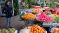 A young Asian girl sells fruit on a city street