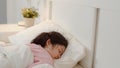 Young Asian girl sleeping at home. Asia japanese woman child kid relax rest asleep lying on bed, feel comfort and calm in bedroom Royalty Free Stock Photo