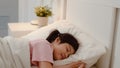 Young Asian girl sleeping at home. Asia japanese woman child kid relax rest asleep lying on bed, feel comfort and calm in bedroom Royalty Free Stock Photo