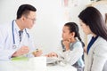 Young asian girl with sore throat come to visit doctor with her