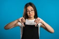 Young asian girl standing on blue studio background expressing discontent Royalty Free Stock Photo