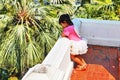 Young Asian girl thinking as she gazes over a wall. Royalty Free Stock Photo