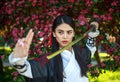 Young asian girl in traditional kimano in a blooming garden with samurai japanese sword katana in image of warrior woman Royalty Free Stock Photo