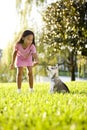 Young Asian girl training puppy to sit