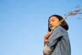 Young asian girl wear Jetket Jean hold grass flower .Blue sky background Royalty Free Stock Photo