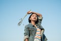 Young asian girl wear Jetket Jean hold grass flower .Blue sky background Royalty Free Stock Photo