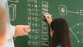 Young asian girl writing math formula at blackboard while standing. Pedagogy. Royalty Free Stock Photo