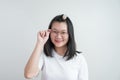 Young Asian glasses girl touches her glasses and smiles to camera on studio light white clear background. Clipping Path Royalty Free Stock Photo